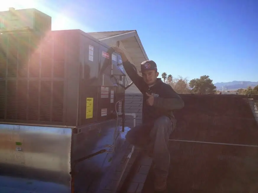 HVAC technician performing Air Duct Cleaning on a rooftop unit in Sterling Heights